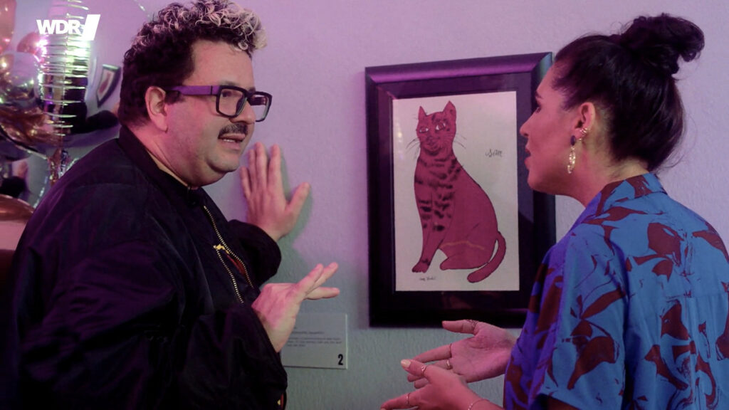 Comedian Oliver Polak und Moderatorin Ariana Baborie vor dem Druck "Red Cat" von Andy Warhol